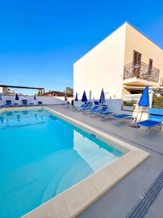 Piscina stagionale con lettini e ombrelloni